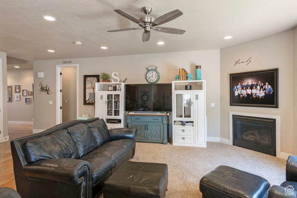 Living room featuring a glass covered fireplace, recessed lighting, and a ceiling fan