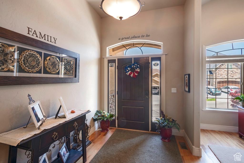 Foyer featuring light wood finished floors and a towering ceiling
