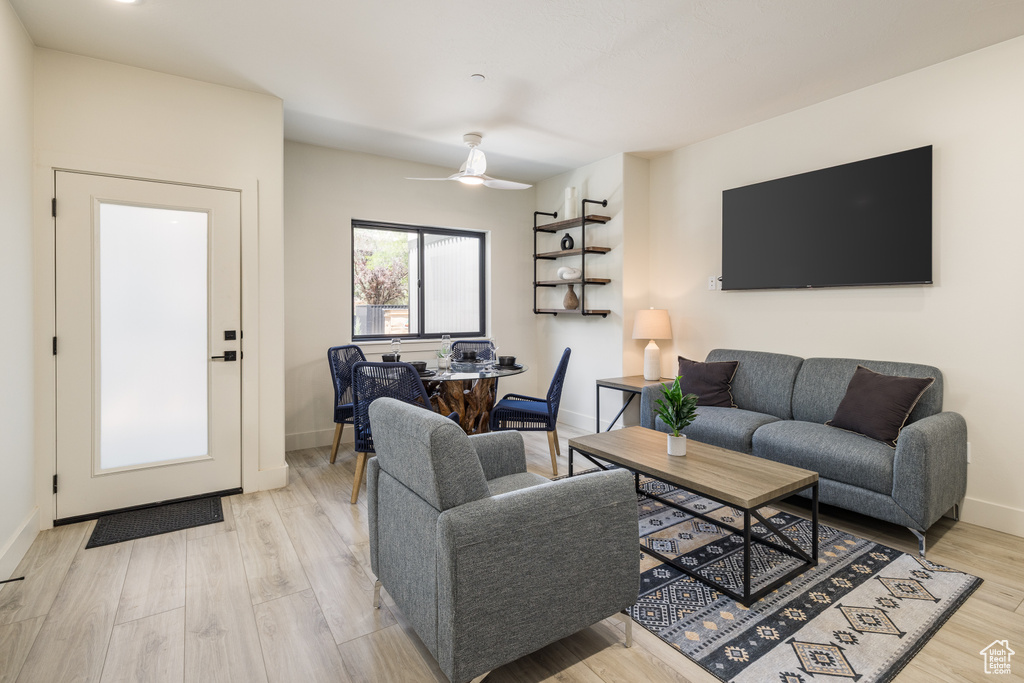 Living area featuring baseboards, light wood-style flooring, and ceiling fan