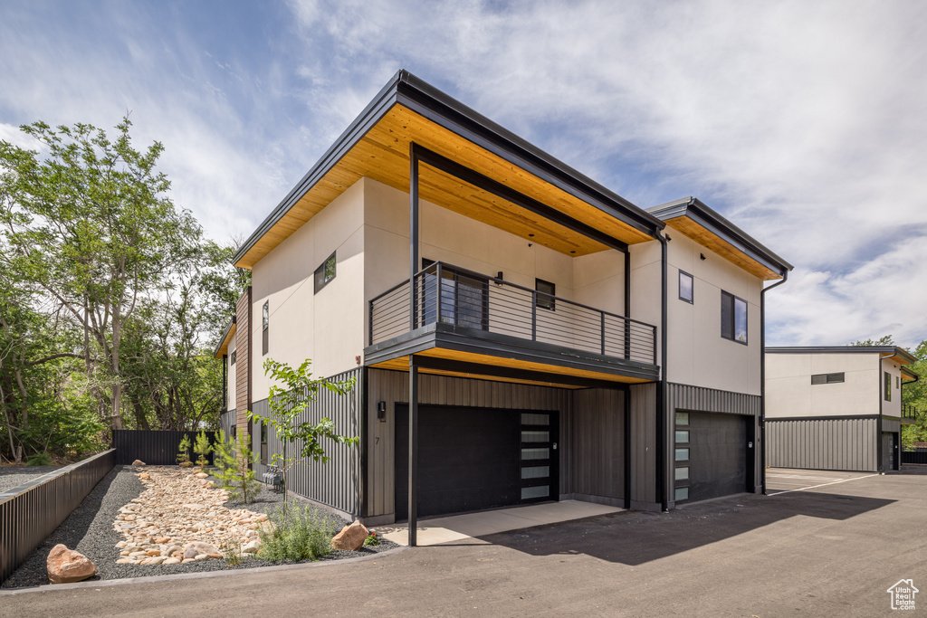 View of front of property with a balcony and an attached garage