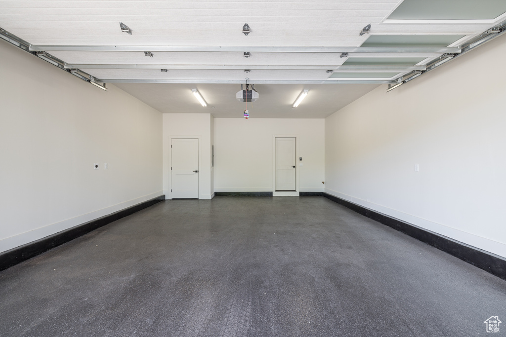 Garage with a garage door opener and baseboards