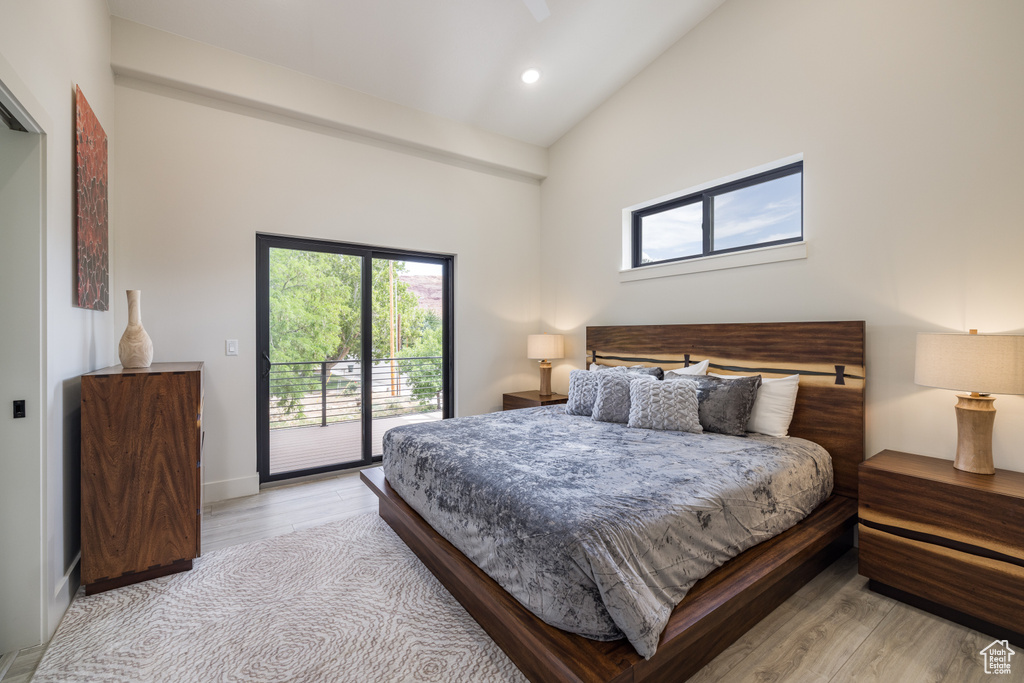 Bedroom with access to exterior, vaulted ceiling, light wood-style floors, multiple windows, and recessed lighting