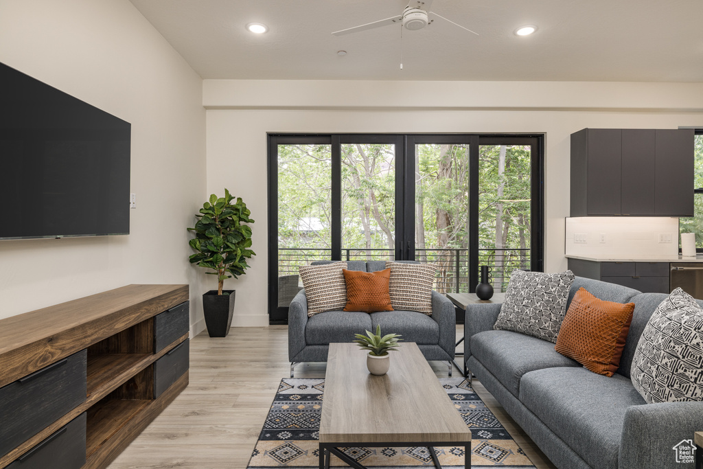 Living area featuring light wood-style flooring, recessed lighting, a ceiling fan, and baseboards