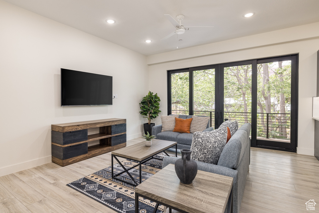 Living room with baseboards, a ceiling fan, recessed lighting, and light wood finished floors