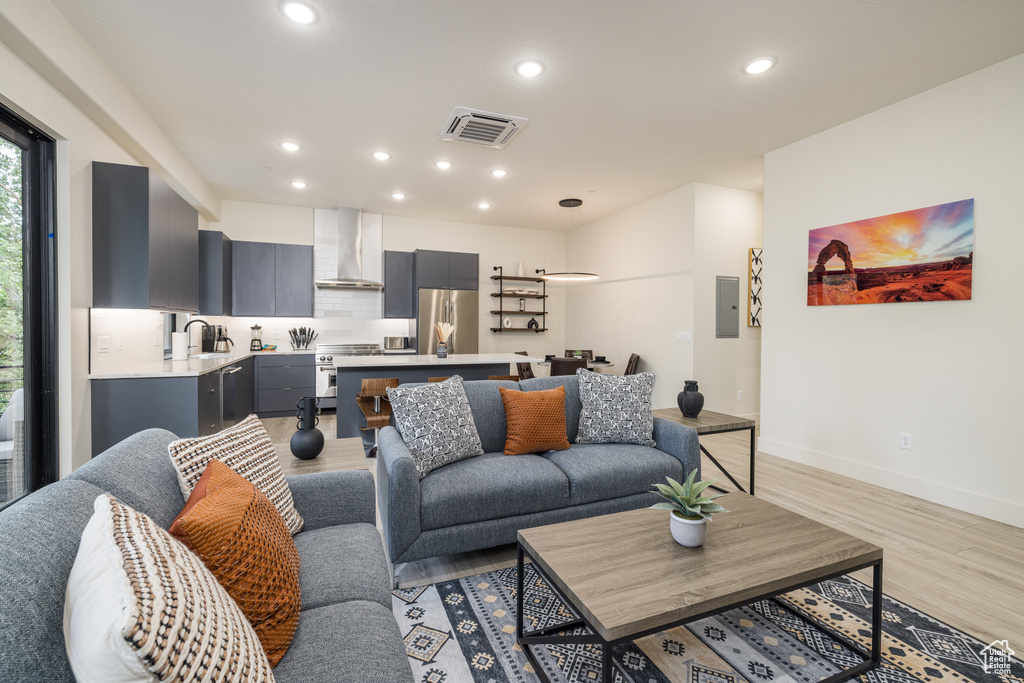 Living room with light wood-type flooring, recessed lighting, and baseboards