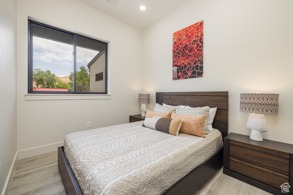 Bedroom with light wood-type flooring, baseboards, and recessed lighting