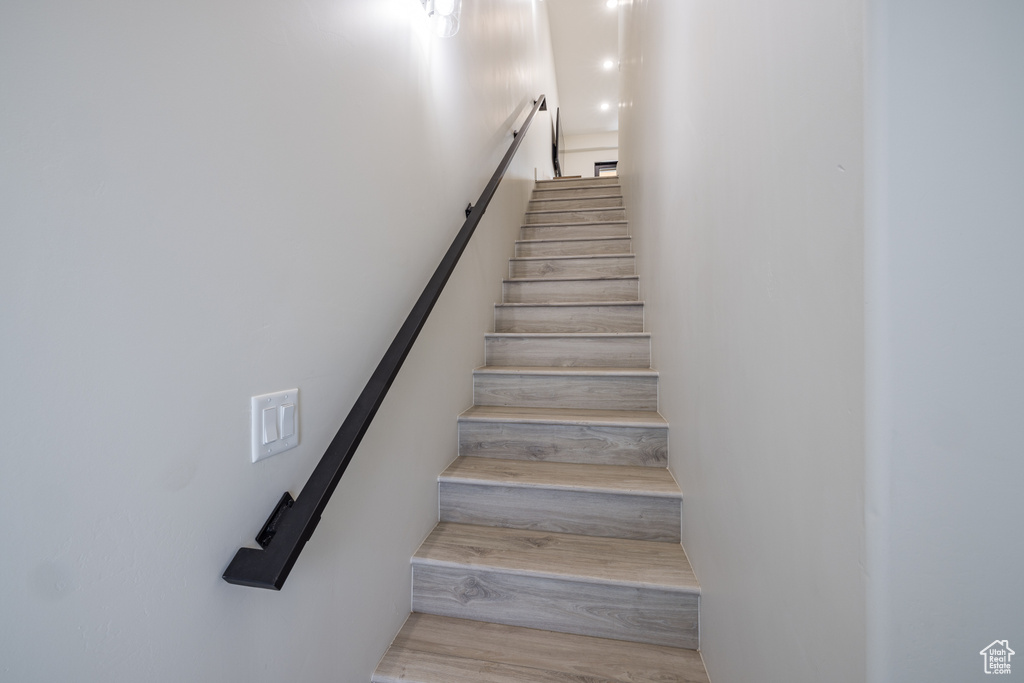 Staircase featuring wood finished floors