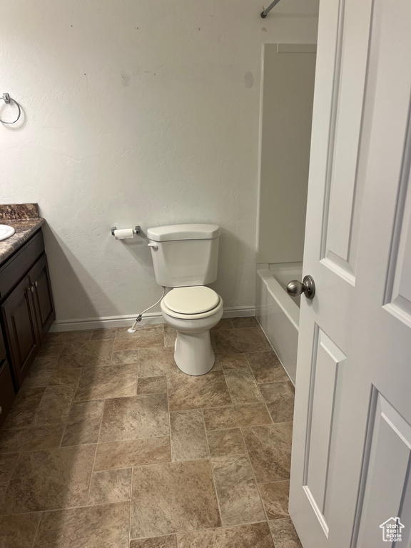 Bathroom featuring vanity, stone finish flooring, and shower / bathtub combination