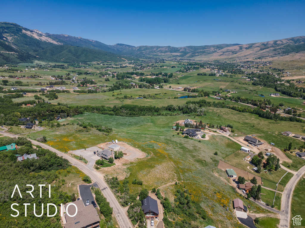 Aerial view of property's location featuring a mountainous background and rural landscape