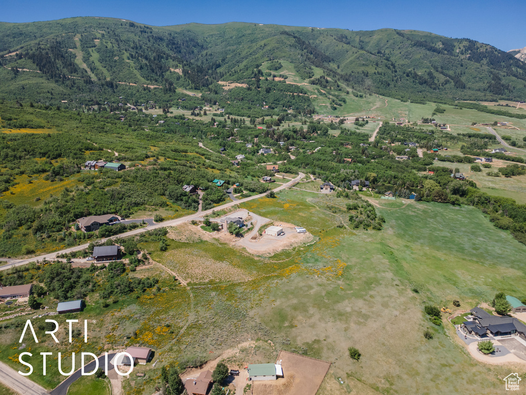 Aerial view of property and surrounding area with a mountain backdrop