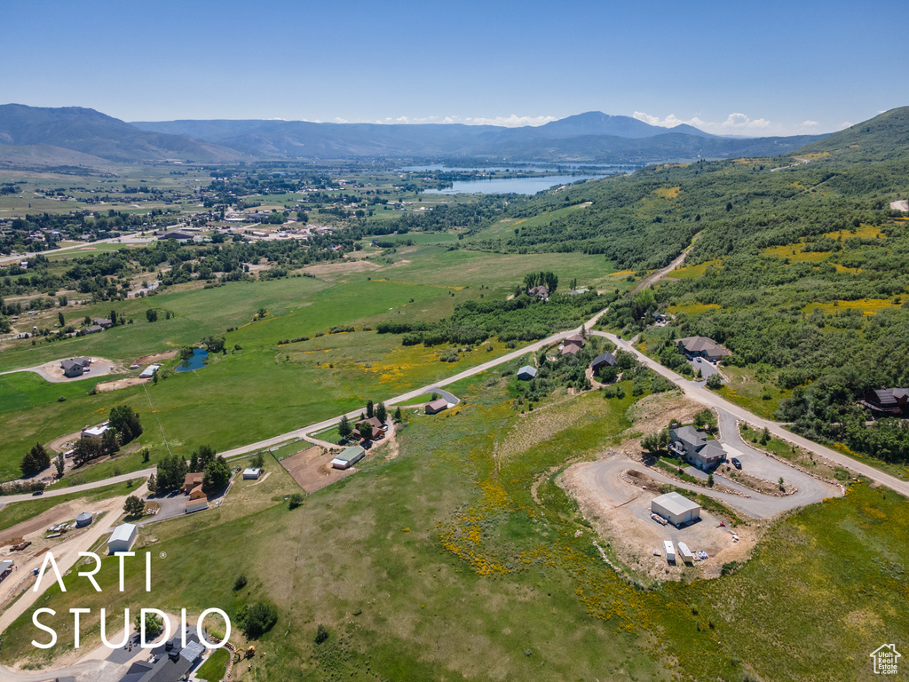Aerial view of property and surrounding area featuring a water and mountain view
