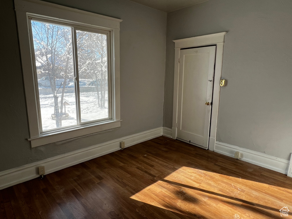 Empty room with dark wood finished floors and baseboards