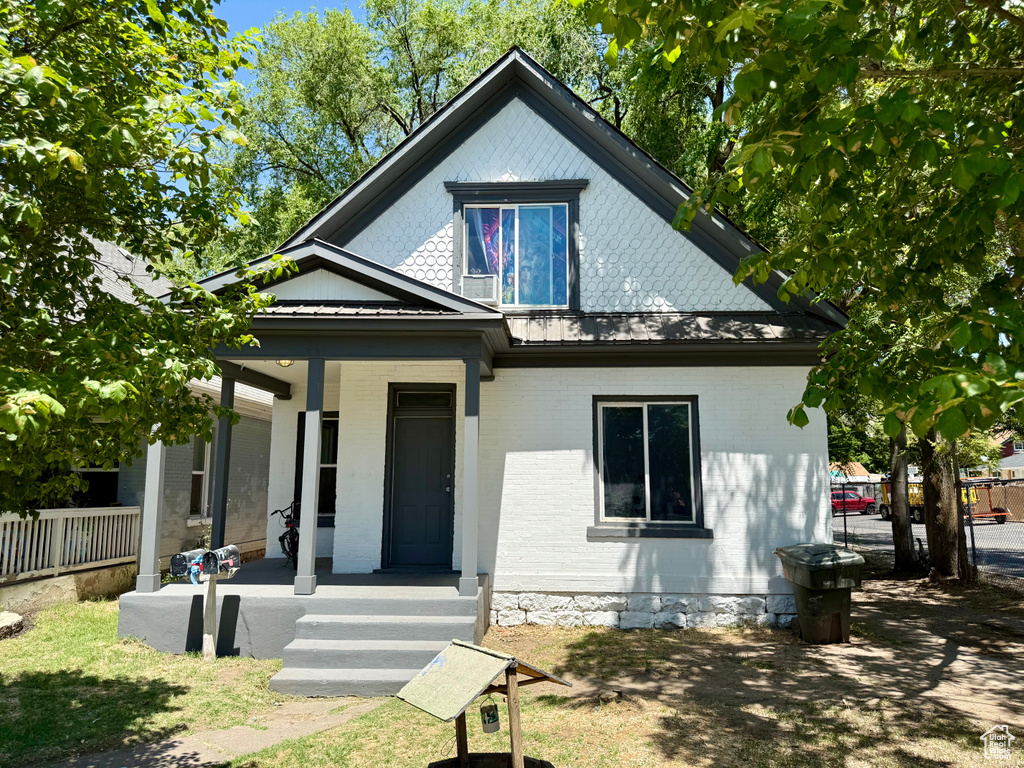 Bungalow-style house with covered porch and brick siding