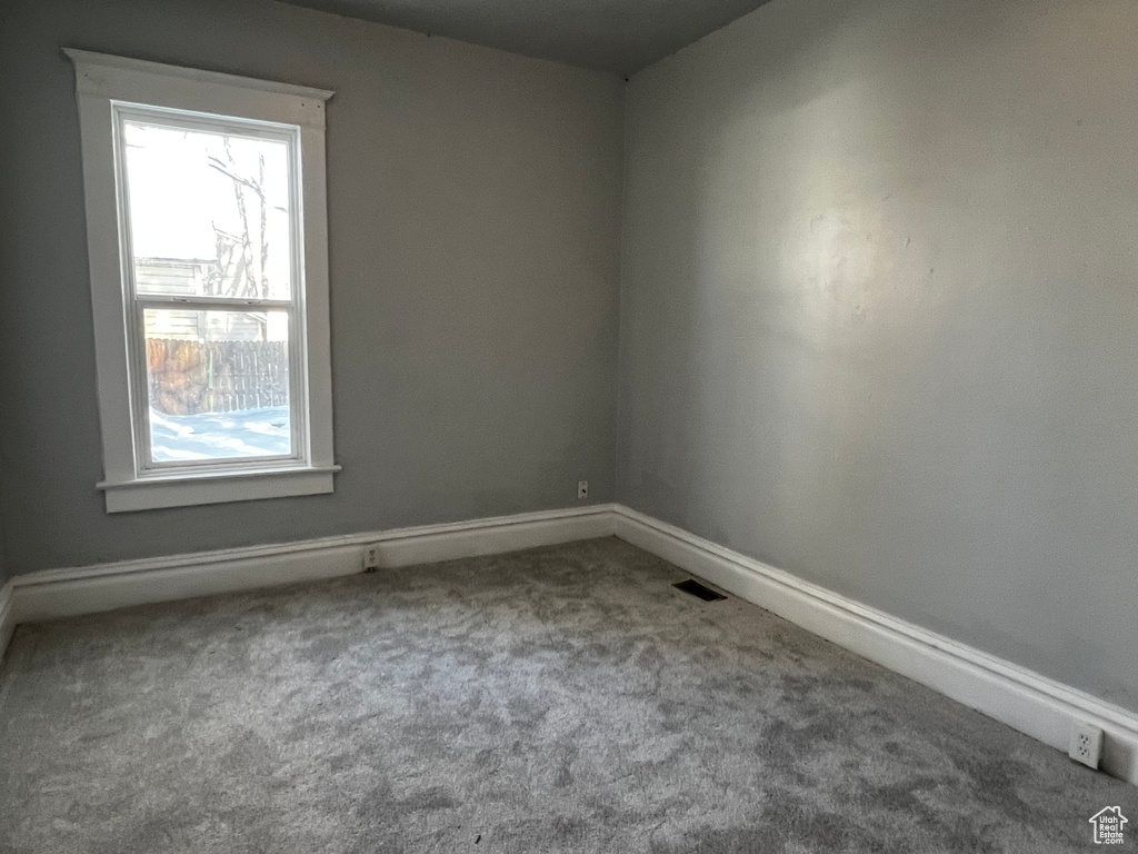 Carpeted spare room with baseboards