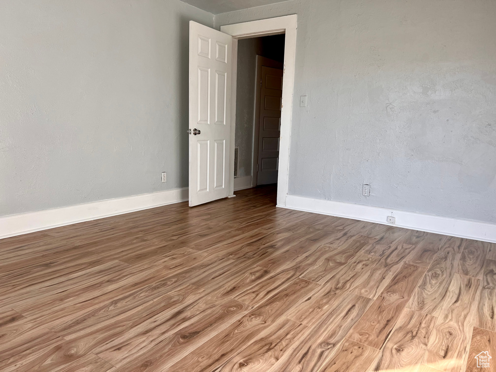 Unfurnished room with wood finished floors and baseboards