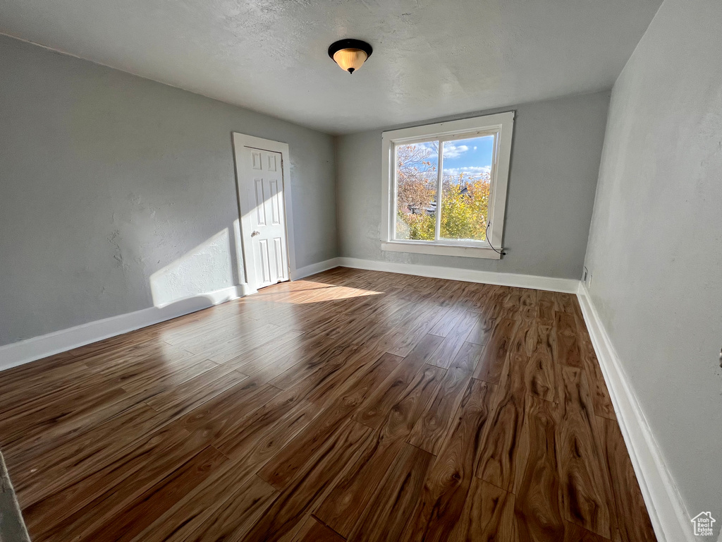Spare room featuring dark wood-type flooring