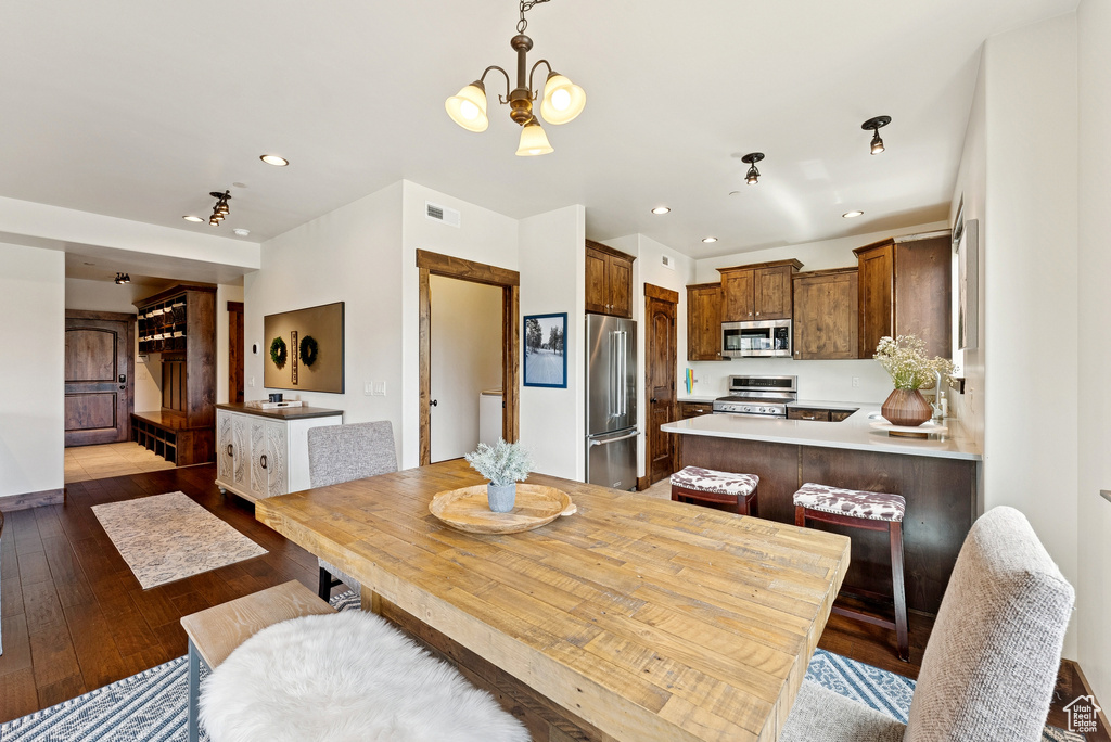 Dining area with wood-type flooring, recessed lighting, and a chandelier