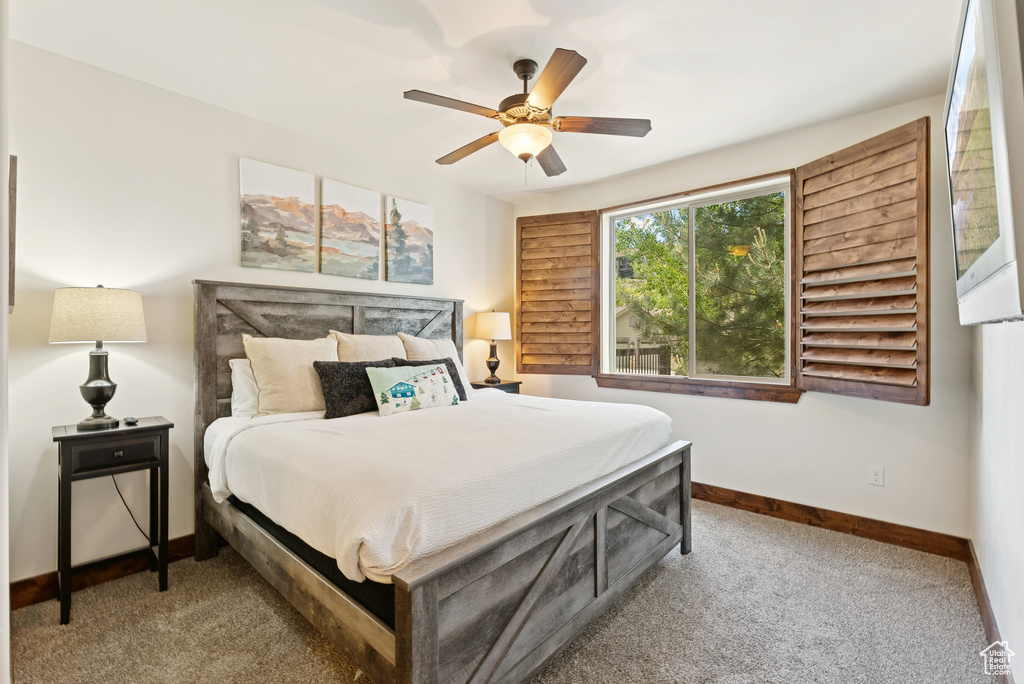 Carpeted bedroom with baseboards and ceiling fan
