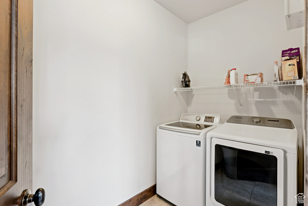 Laundry area featuring washing machine and dryer and baseboards