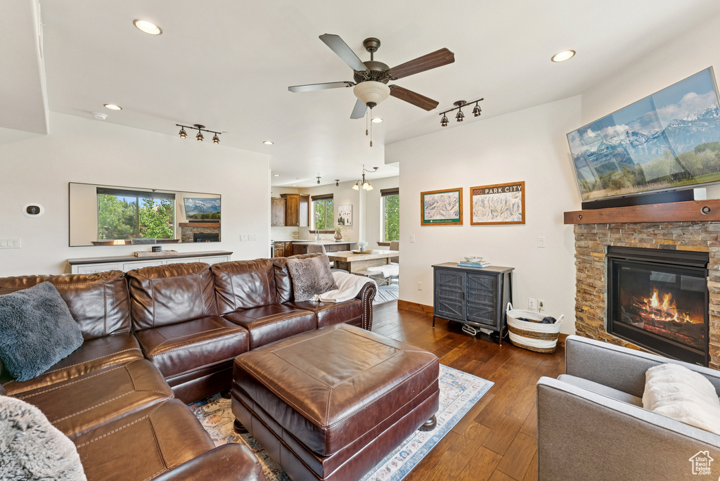 Living area with track lighting, ceiling fan, wood-type flooring, recessed lighting, and a fireplace