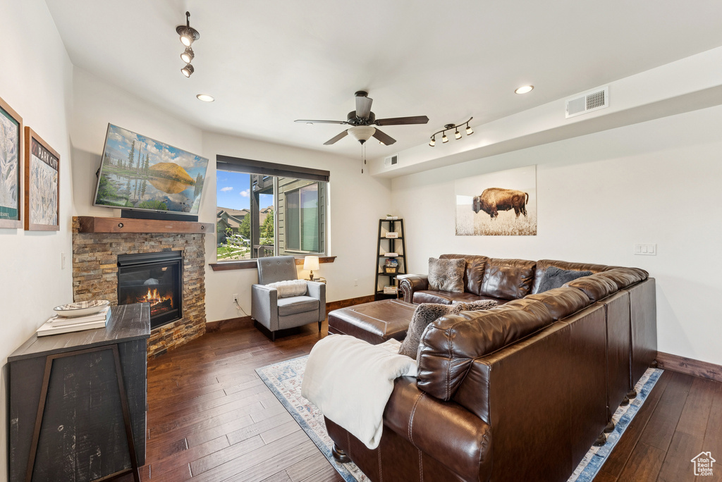 Living area with a ceiling fan, dark wood-style floors, a fireplace, and recessed lighting