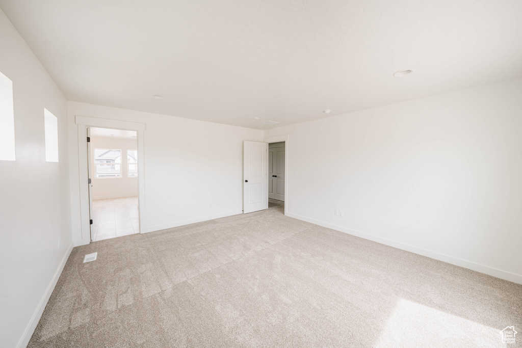Unfurnished room with light carpet and baseboards