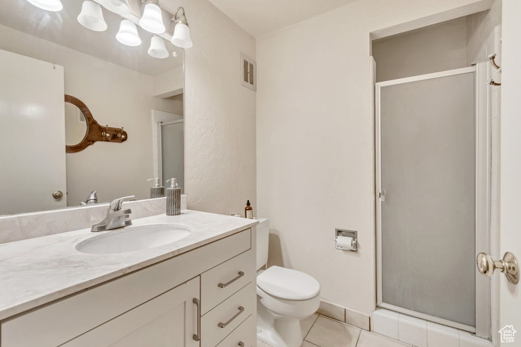 Full bathroom with vanity, a stall shower, and tile patterned floors