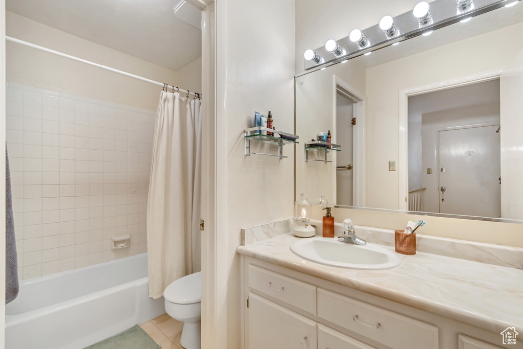Bathroom featuring vanity, shower / bath combo, and tile patterned floors