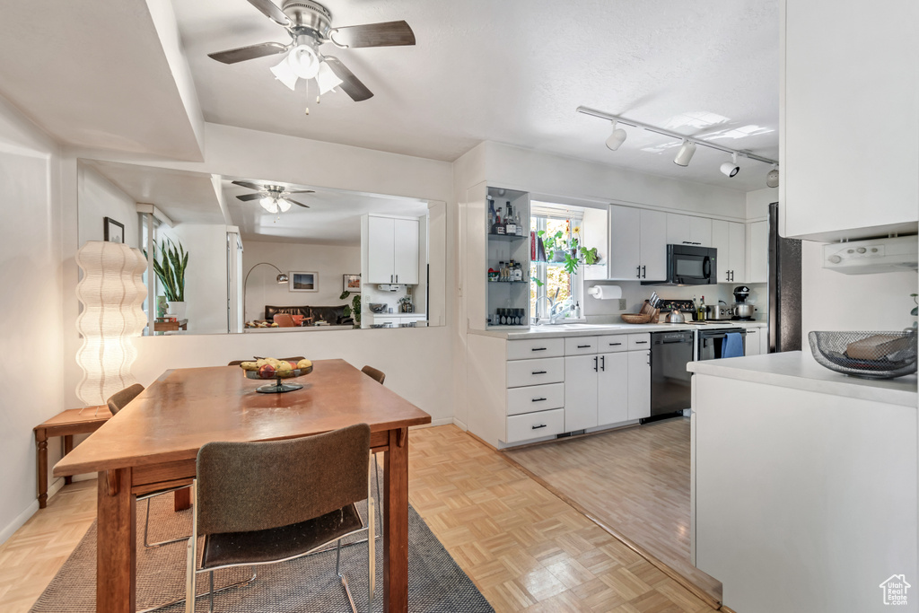 Kitchen with black microwave, dishwashing machine, a ceiling fan, white cabinetry, and light countertops