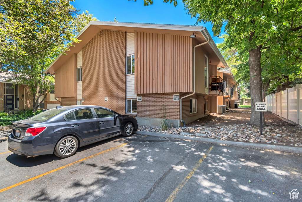 View of side of home featuring brick siding and uncovered parking