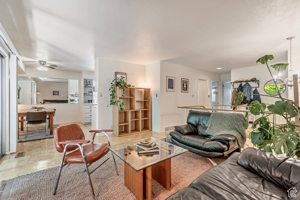 Living area with a ceiling fan and baseboards