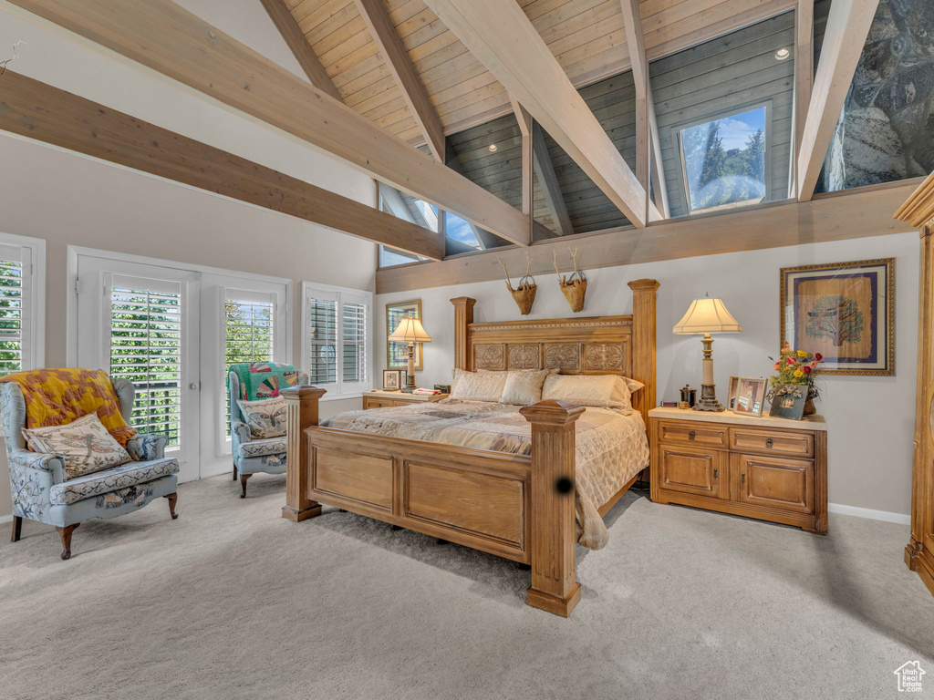 Bedroom with a wooden ceiling with exposed beams, access to exterior, light carpet, and high vaulted ceiling