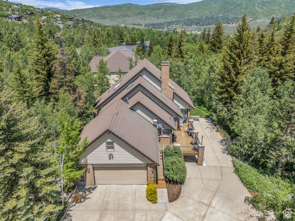 View of subject property featuring a heavily wooded area and mountains