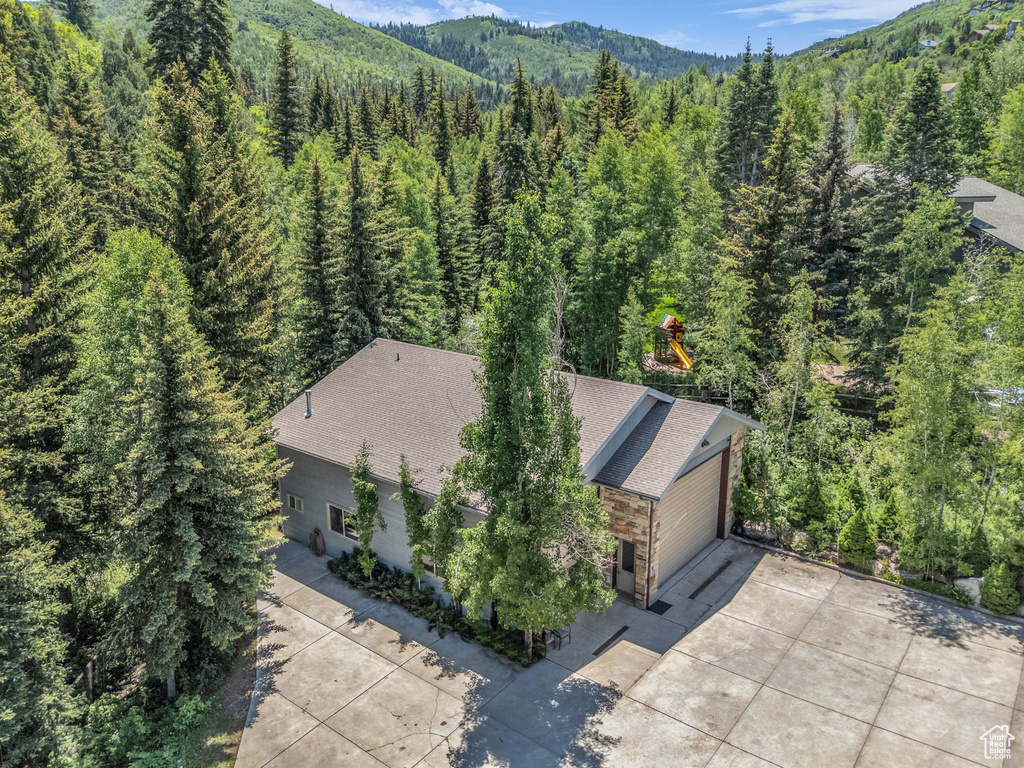 View of subject property featuring a heavily wooded area and a mountainous background