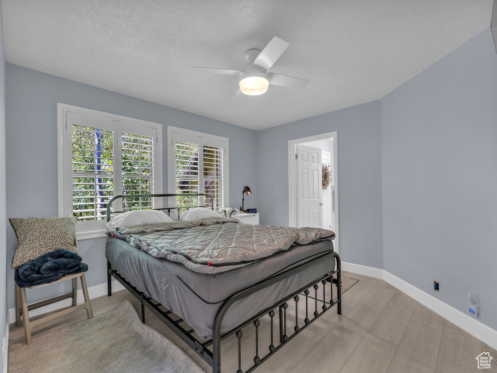 Bedroom with ceiling fan and a textured ceiling
