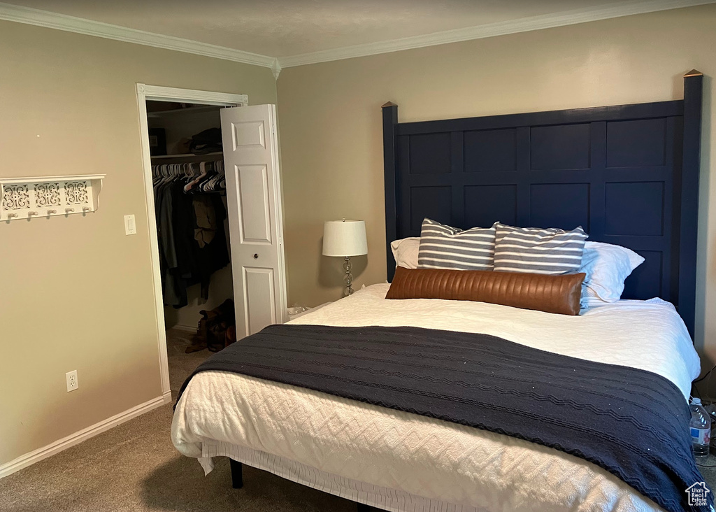 Bedroom with carpet flooring, ornamental molding, and a closet