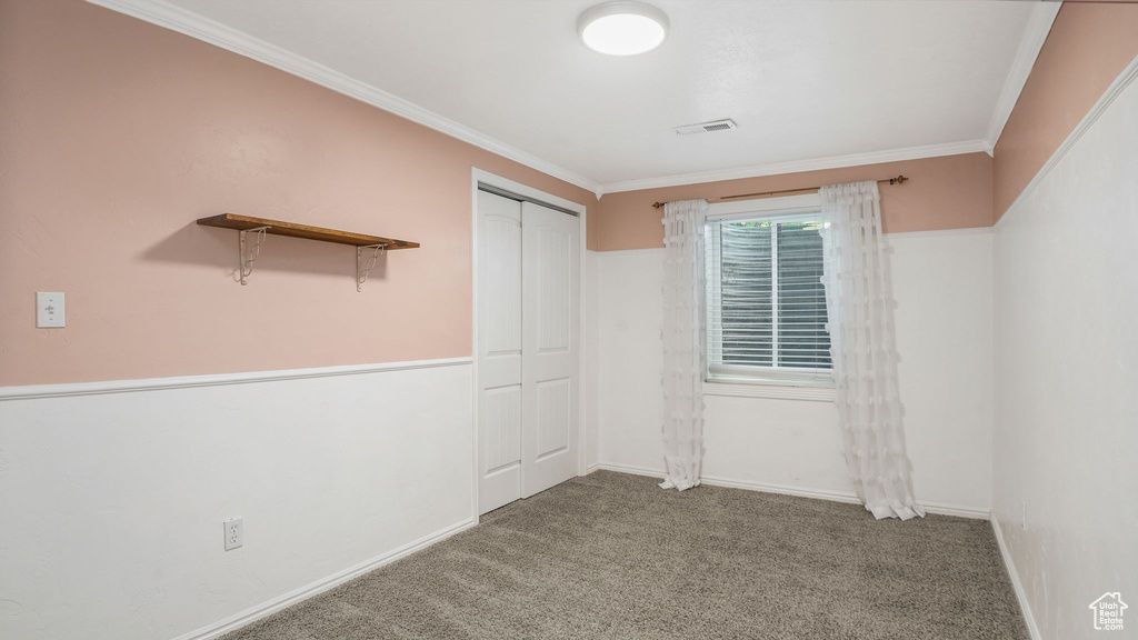 Carpeted spare room featuring ornamental molding and baseboards