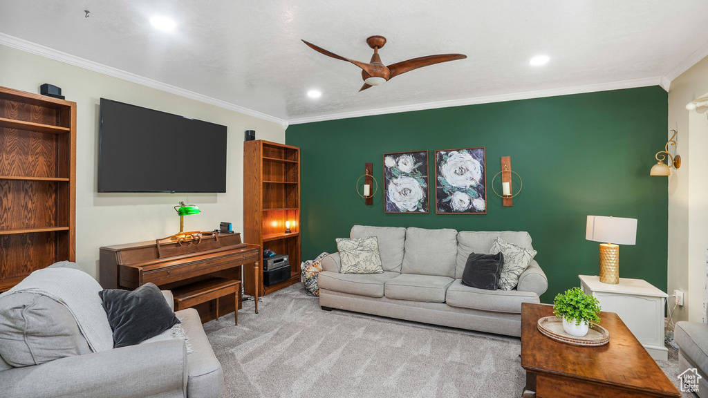 Carpeted living area with crown molding, a ceiling fan, and recessed lighting