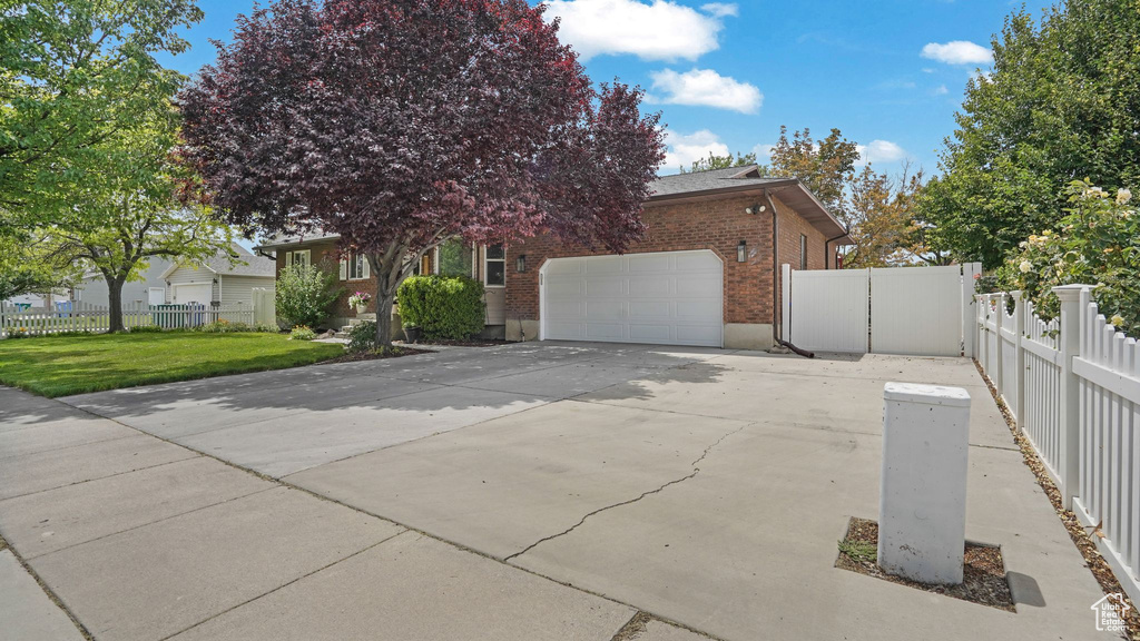 View of property exterior with brick siding, a garage, and driveway