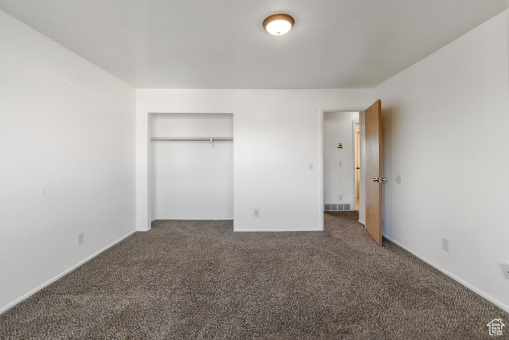 Unfurnished bedroom featuring carpet flooring and a closet