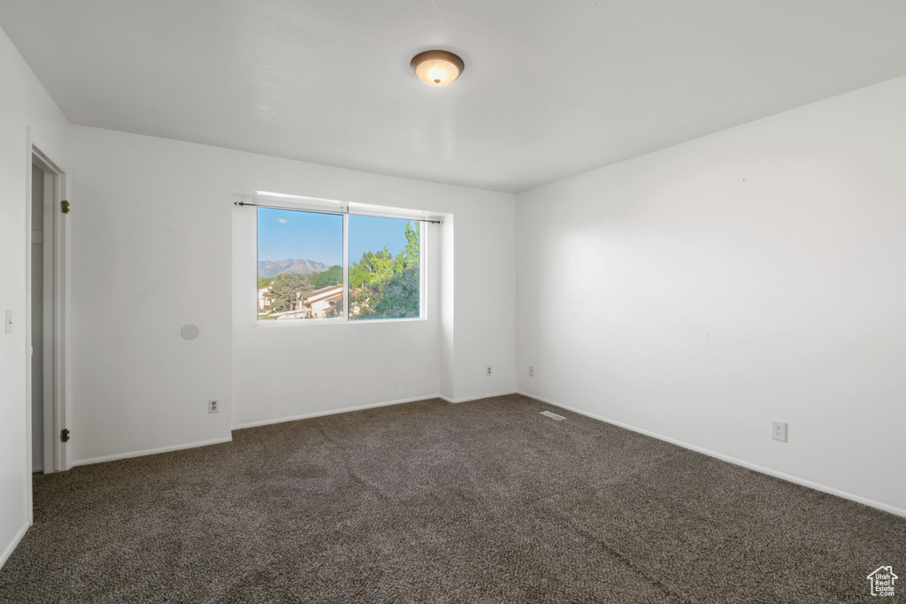 Carpeted empty room featuring baseboards
