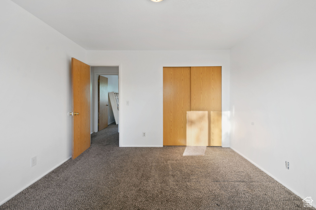 Unfurnished bedroom with carpet floors and baseboards