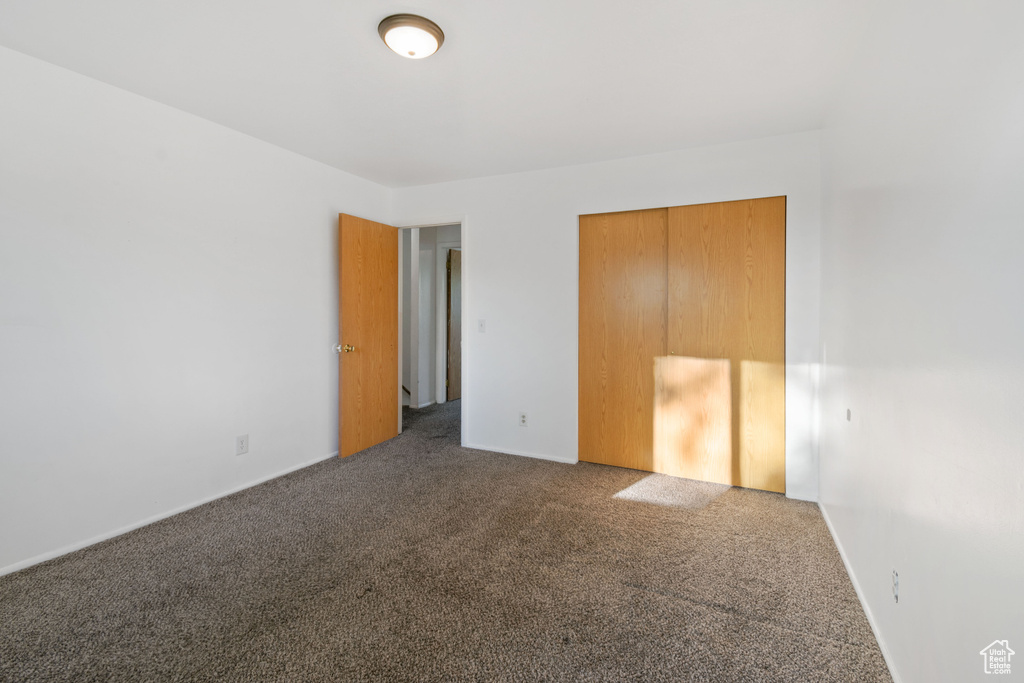Unfurnished bedroom featuring carpet flooring and a closet