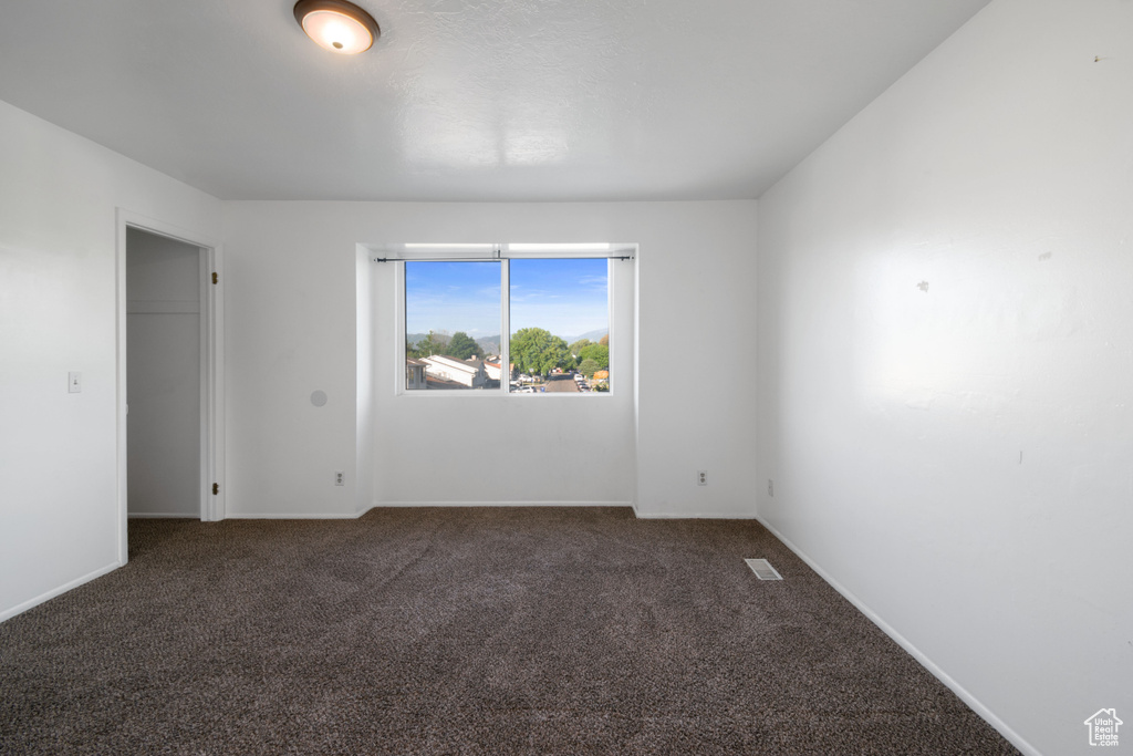 Empty room with carpet and baseboards