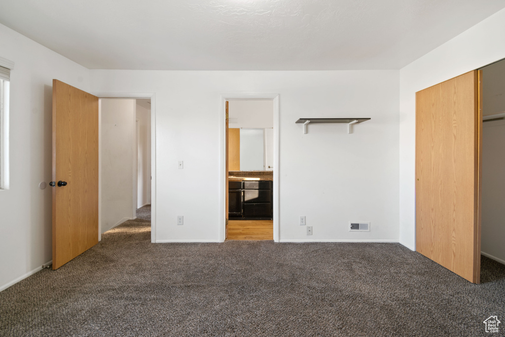 Unfurnished bedroom featuring carpet, a closet, and connected bathroom