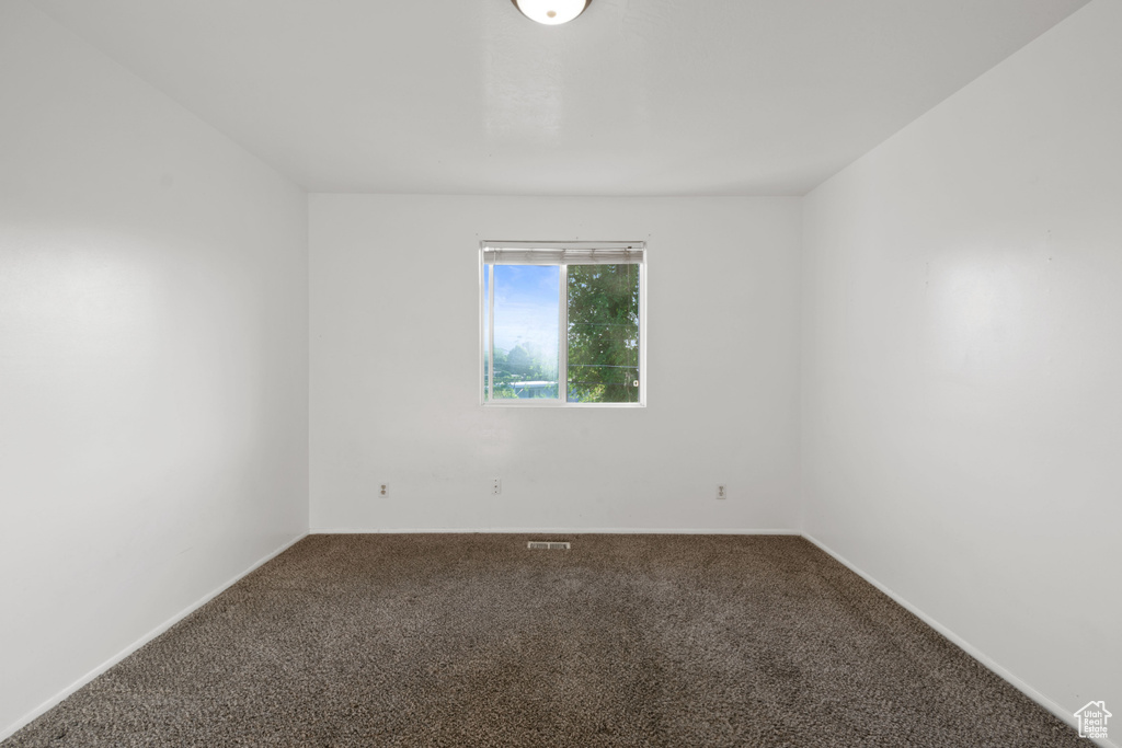 Carpeted empty room featuring baseboards