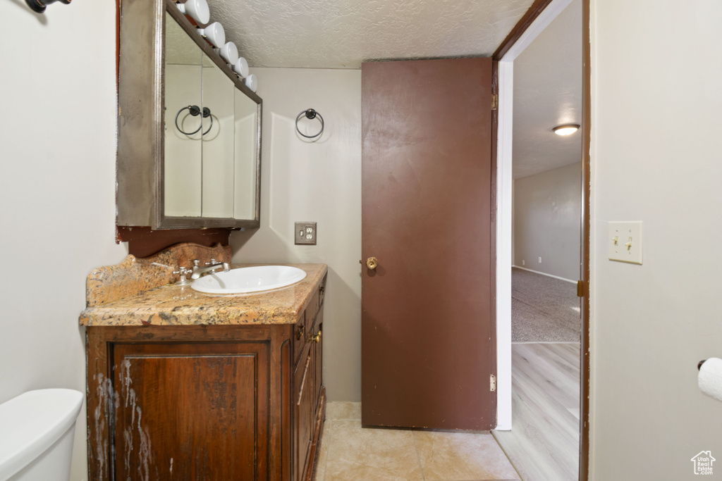 Half bathroom with vanity and a textured ceiling