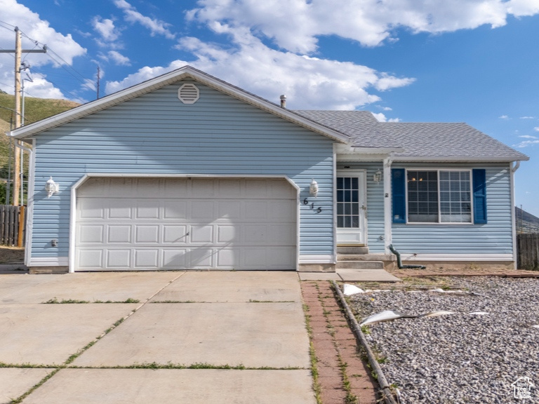 Ranch-style home featuring driveway, an attached garage, and entry steps