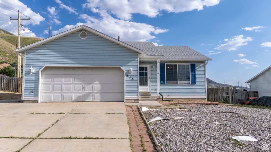 Single story home with driveway, an attached garage, and entry steps