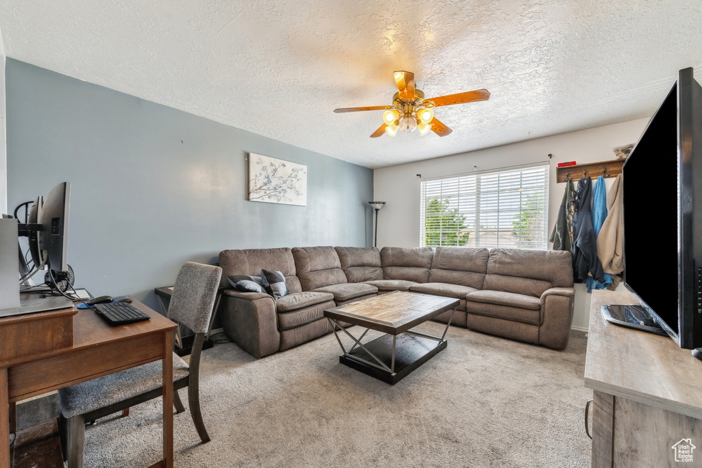 Living room featuring a ceiling fan, a textured ceiling, carpet, and an office area